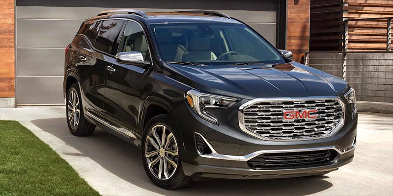 A dark gray 2021 GMC Terrain parked in front of a house. | GMC dealer in Ellisville, MO
